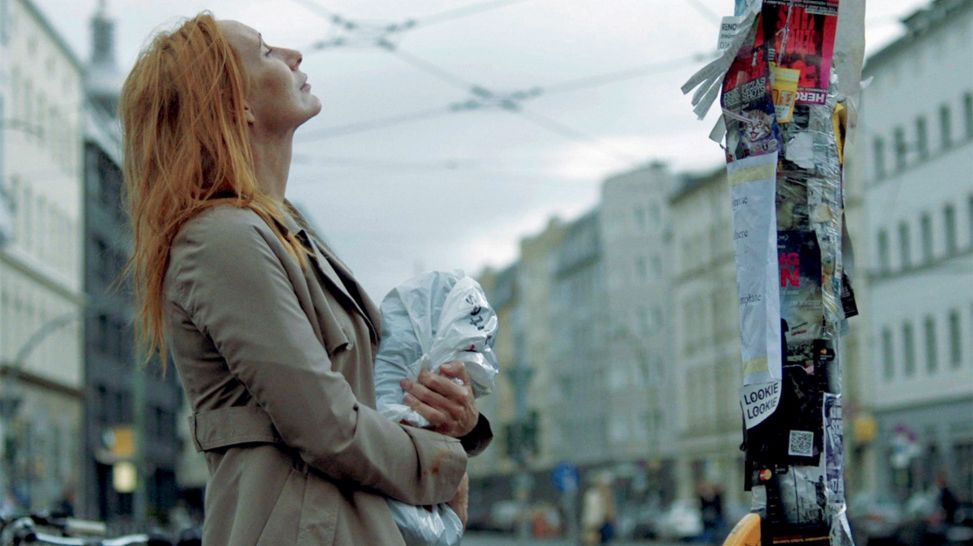 Andrea-Sawatzki in Berlin vor einem Laternenphahl mit Zetteln; Quelle: Carmen Treichl/dffb