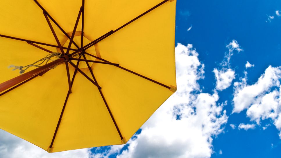 Sommer: Bild zeigt gelben Sonnenschirm vor Himmel (Bild: Colourbox)