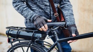 Leasing Fahrrad: Mann mit Lederaktentasche steht am Sattel eines E-Bikes (Bild: colourbox.de)